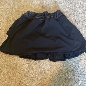 A black lulu lemon tennis skirt. There is a back pocket and built in shorts.